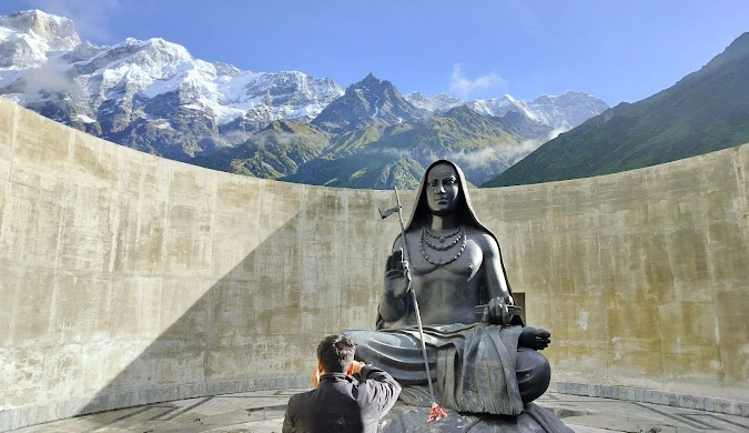 Scenic view of Adi Shankaracharya Statue on hilltop surrounded by mountains during pilgrimage in Uttarakhand